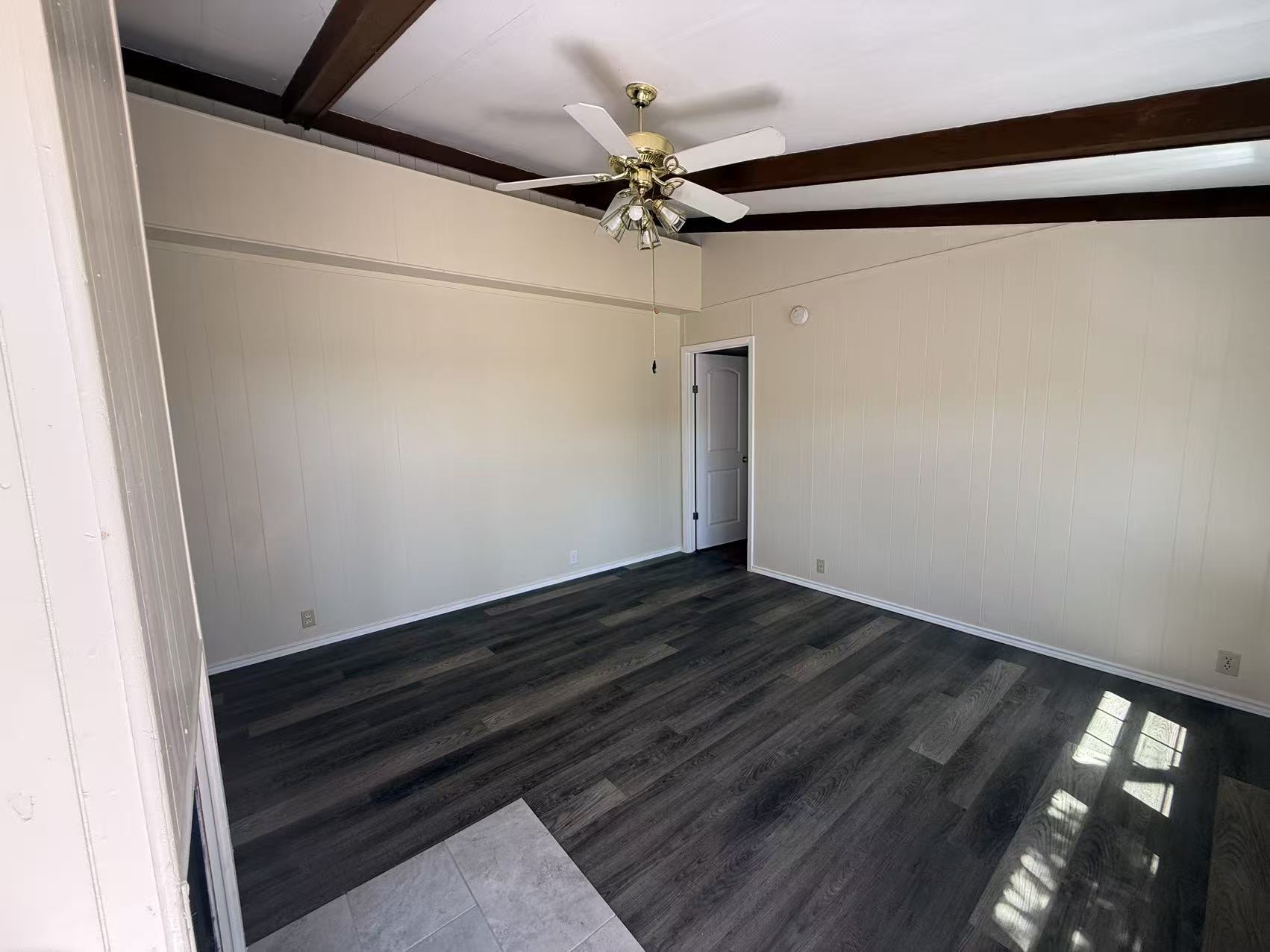 23393 Nameless Road, Unit 113 Leander, TX 78641 - Photo 2 of 16 Unfurnished room with a ceiling fan, dark wood-type flooring, wood walls, and lofted ceiling with beams