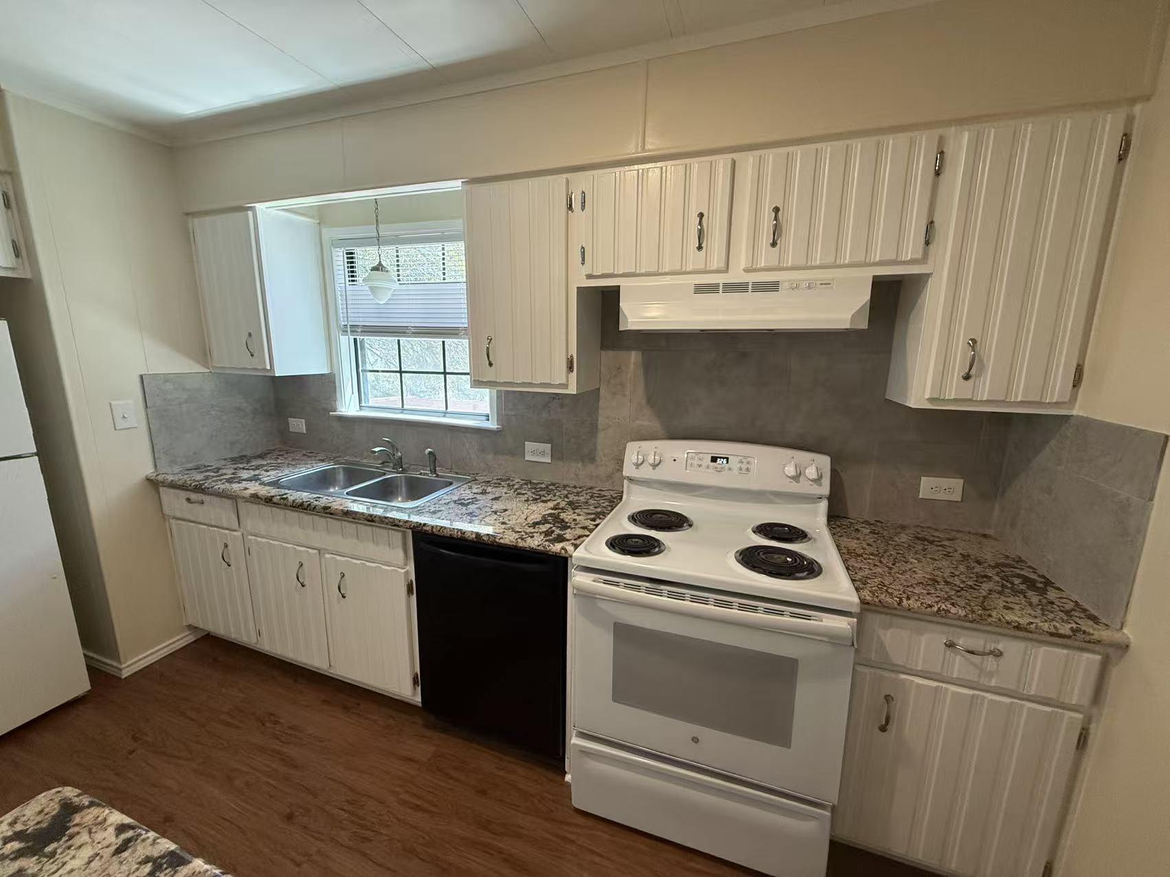 23393 Nameless Road, Unit 113 Leander, TX 78641 - Photo 7 of 16 Kitchen with white appliances, tasteful backsplash, dark wood finished floors, and white cabinetry