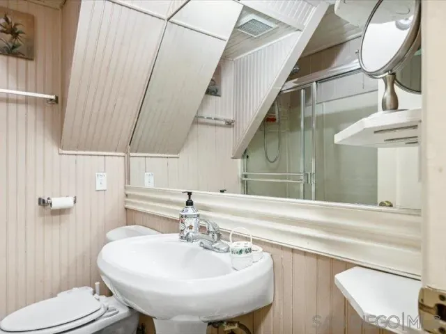 a bathroom with a sink a toilet and mirror