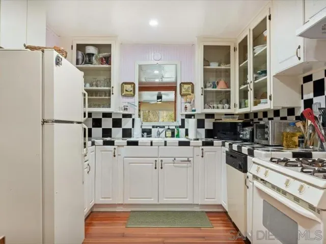 a kitchen with stainless steel appliances a refrigerator and white cabinets