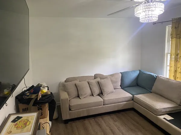 an empty room with wooden floor and cabinet