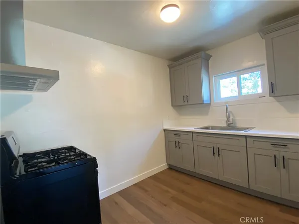 a kitchen with granite countertop cabinets and stove top oven