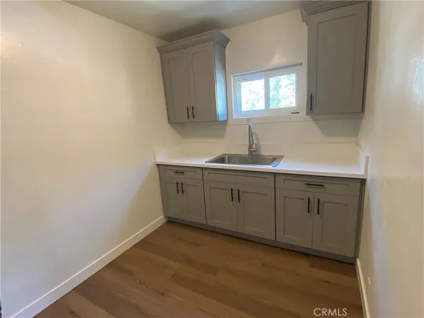 a kitchen with sink cabinets and wooden floor