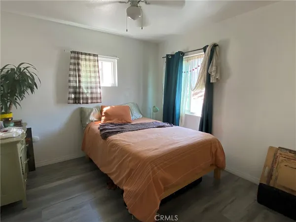 a bedroom with a bed and a potted plant on the dresser