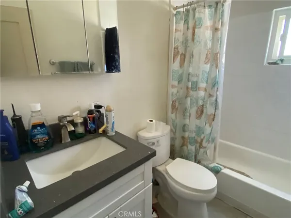 a bathroom with a sink a toilet and shower curtain