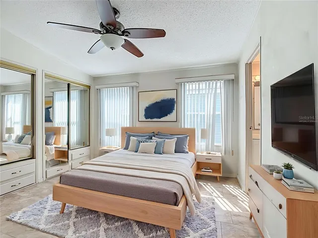 a bedroom with a bed flat screen tv and a couch