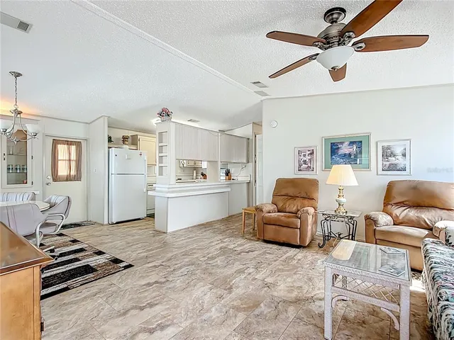 a living room with furniture and kitchen view