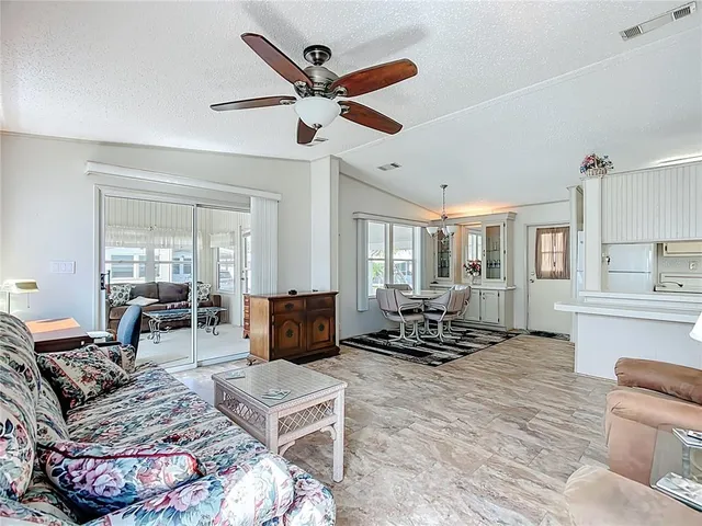 a living room with furniture ceiling fan and a window