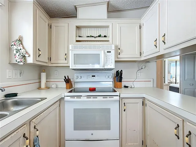 a kitchen with cabinets appliances a sink and a counter top