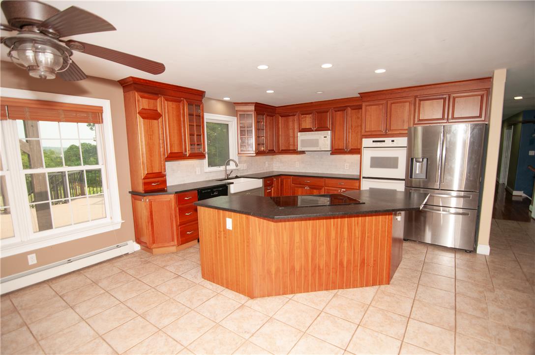 2202 High Meadow Road Coopersburg, PA 18036 - Photo 7 of 41 Rich wood cabinetry and a central island ground this tile-floor kitchen.