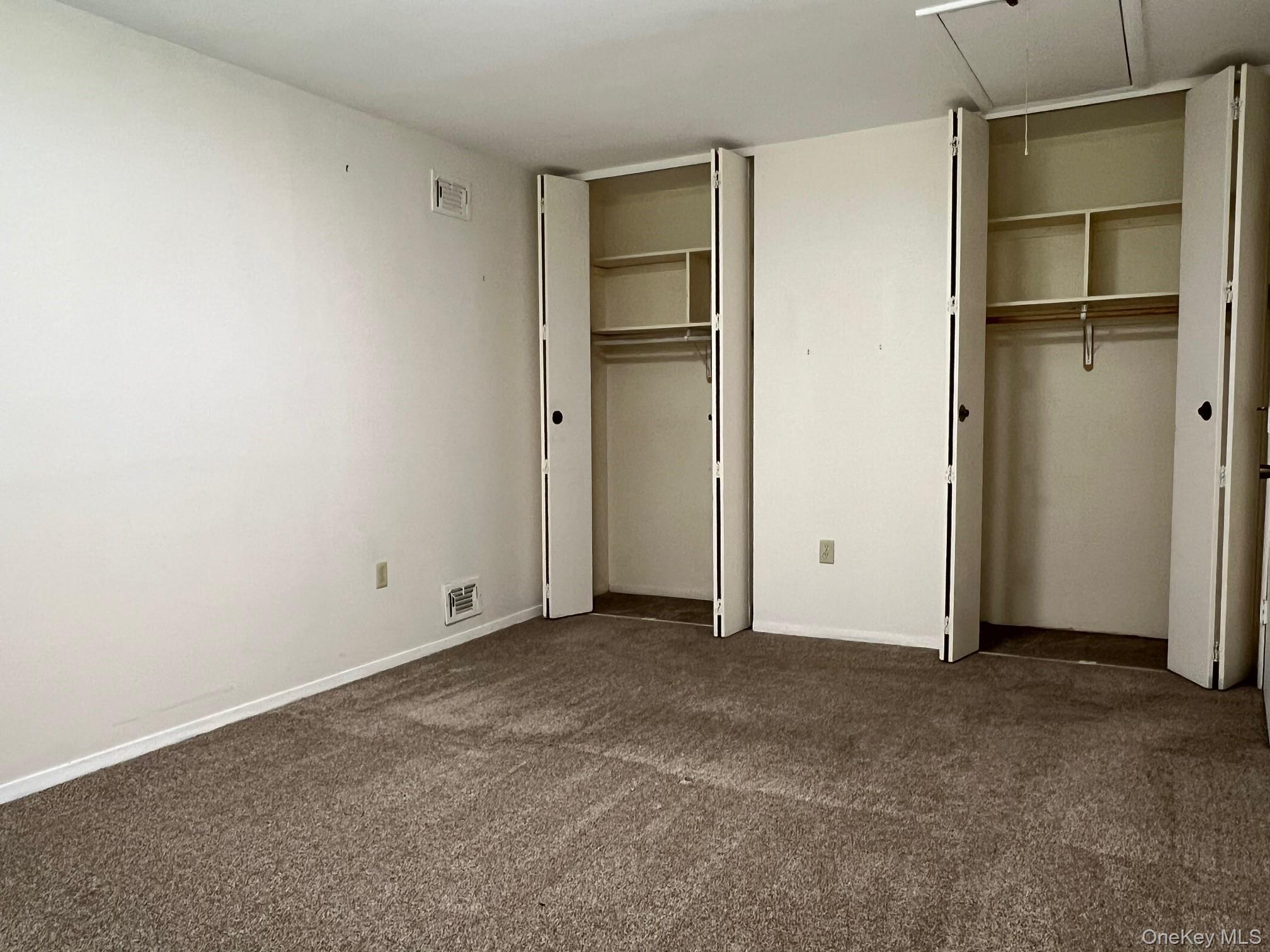 1006 Holly Walk Poughkeepsie, NY 12603 - Photo 11 of 18 Unfurnished bedroom with multiple closets, dark colored carpet, and attic access