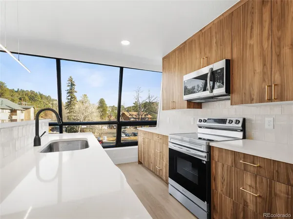 a kitchen with stainless steel appliances a stove sink and microwave