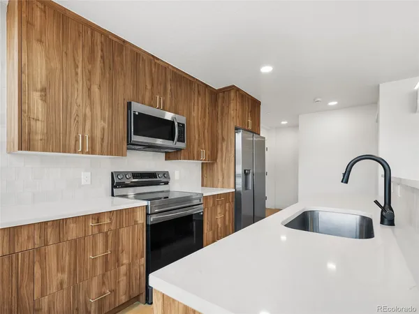 a kitchen with stainless steel appliances a stove sink microwave and refrigerator