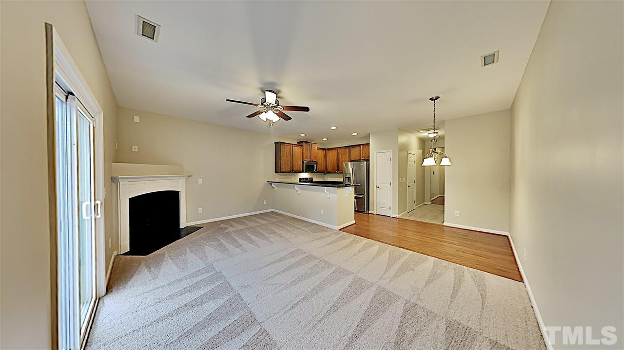 2238 Stoney Spring Drive Raleigh, NC 27610 - Photo 3 of 11 a view of a livingroom with a fireplace a ceiling fan and wooden floor