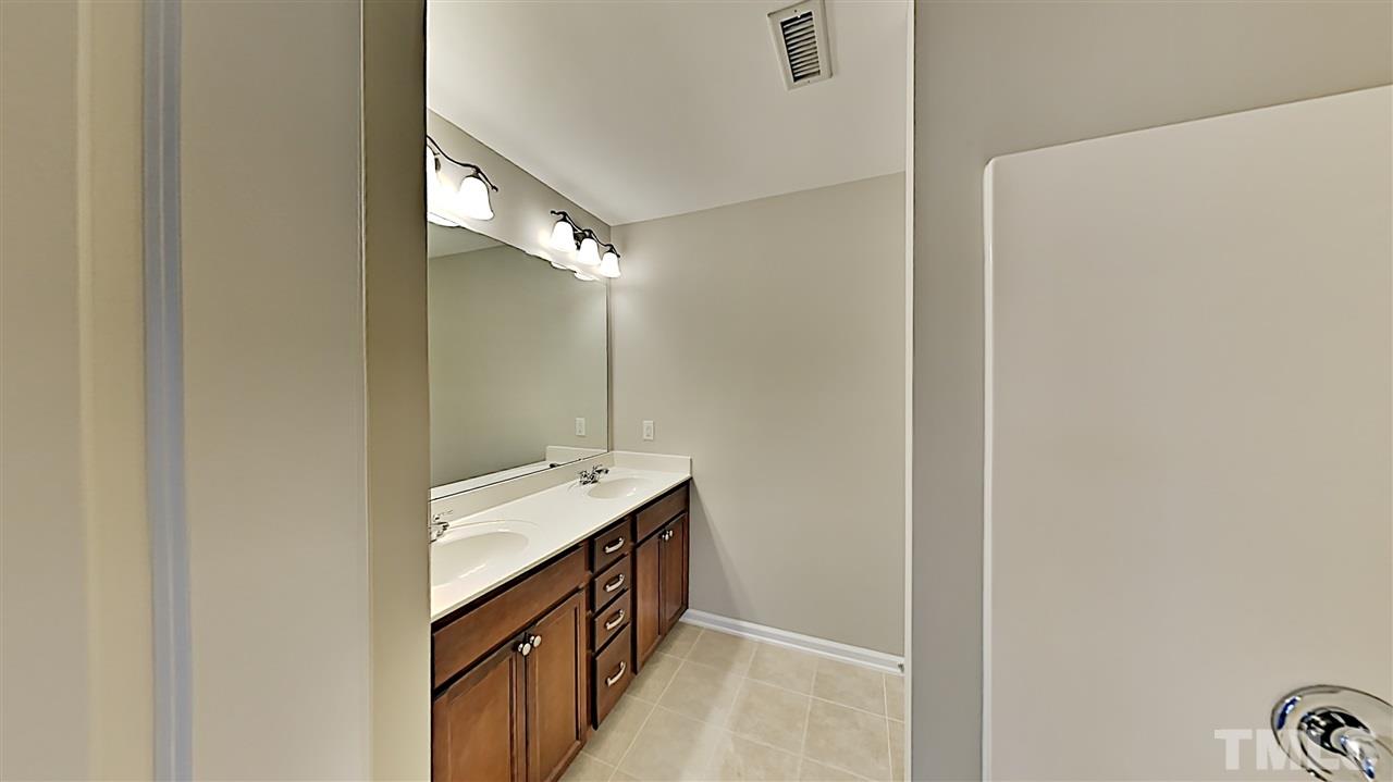 2238 Stoney Spring Drive Raleigh, NC 27610 - Photo 7 of 11 a bathroom with a sink a mirror and a shower