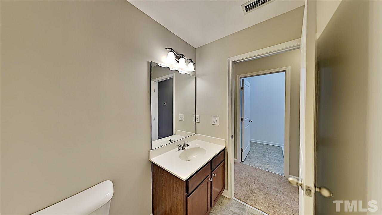 2238 Stoney Spring Drive Raleigh, NC 27610 - Photo 10 of 11 a bathroom with a light fixture a sink and a mirror