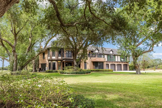 a front view of building with yard and trees