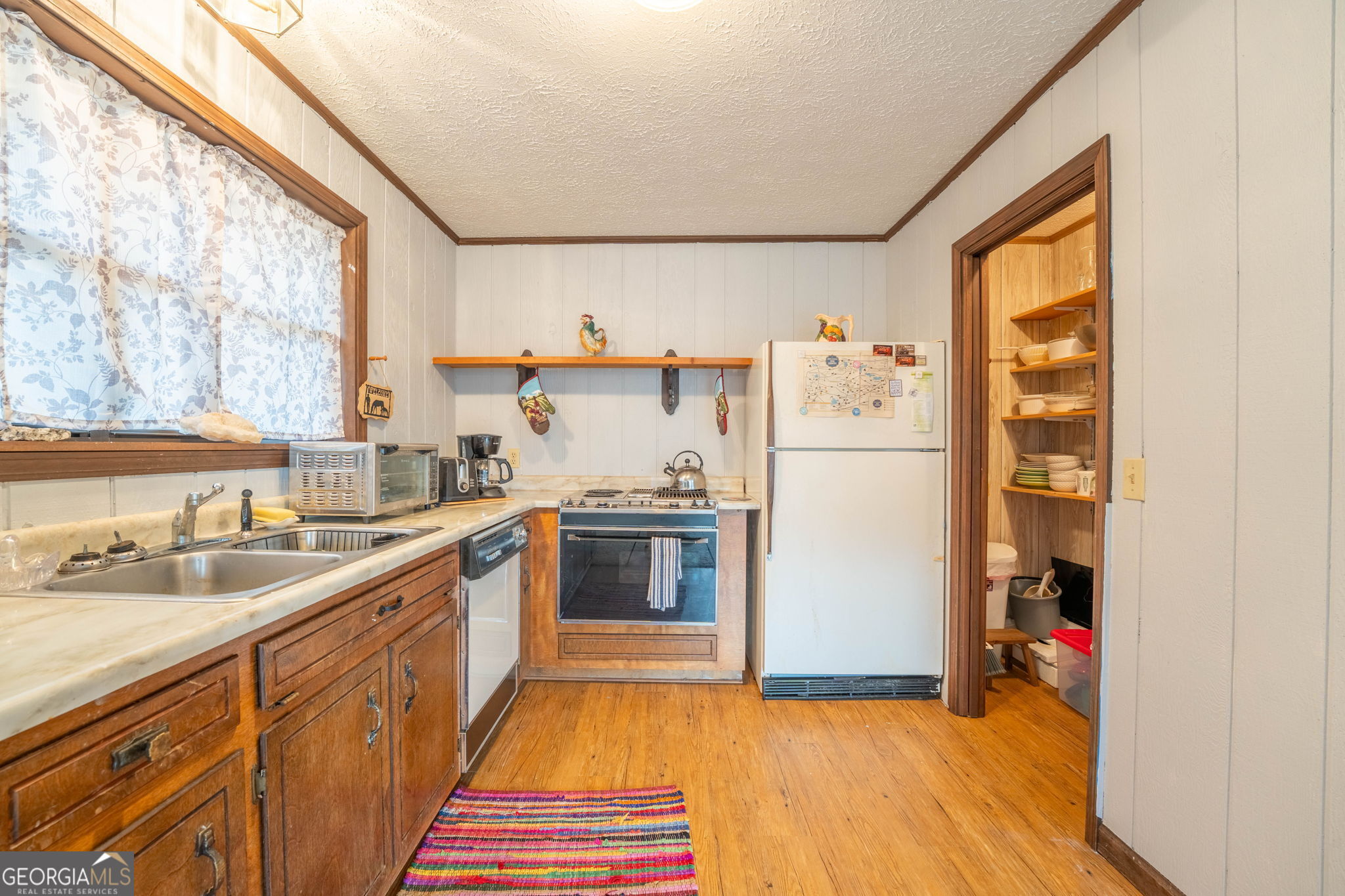 375 Western Way Rabun Gap, GA 30568 - Photo 19 of 51 a kitchen with stainless steel appliances a refrigerator sink and wooden cabinets