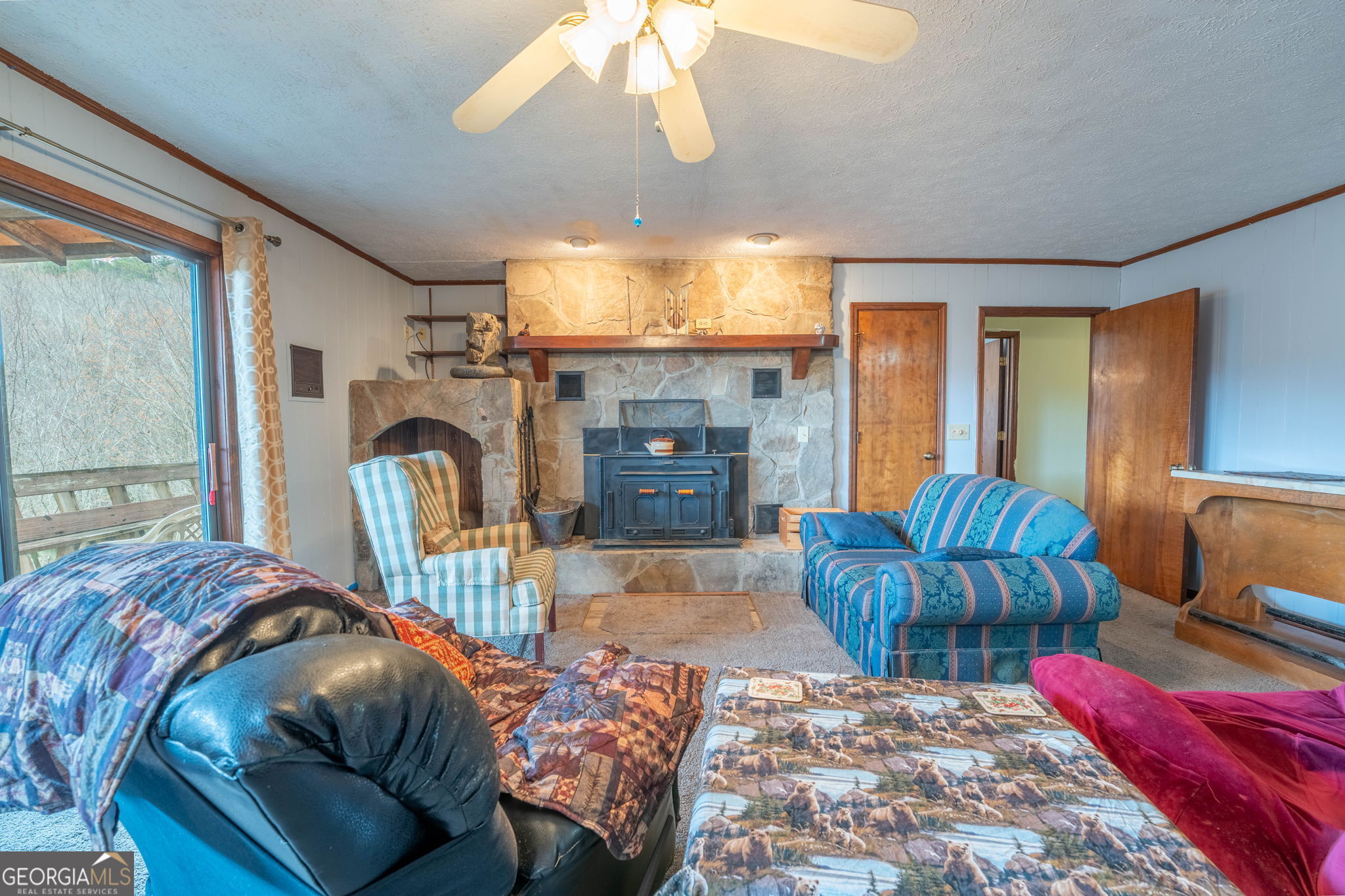 375 Western Way Rabun Gap, GA 30568 - Photo 29 of 51 a living room with furniture a fireplace and a chandelier