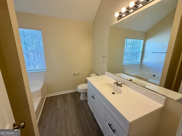 a bathroom with a sink a toilet and mirror