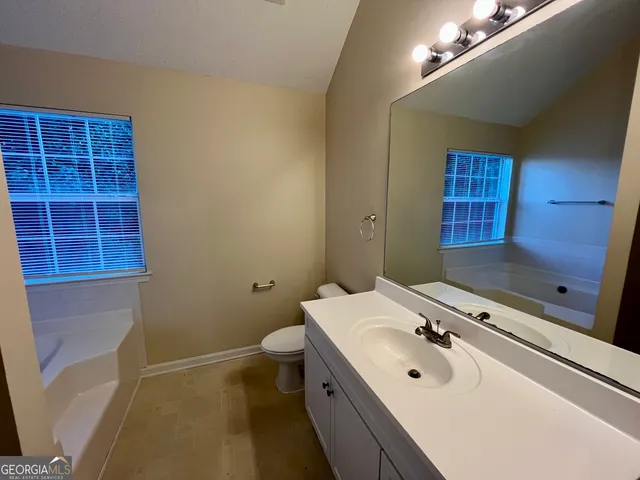 a bathroom with a sink double vanity granite and a toilet