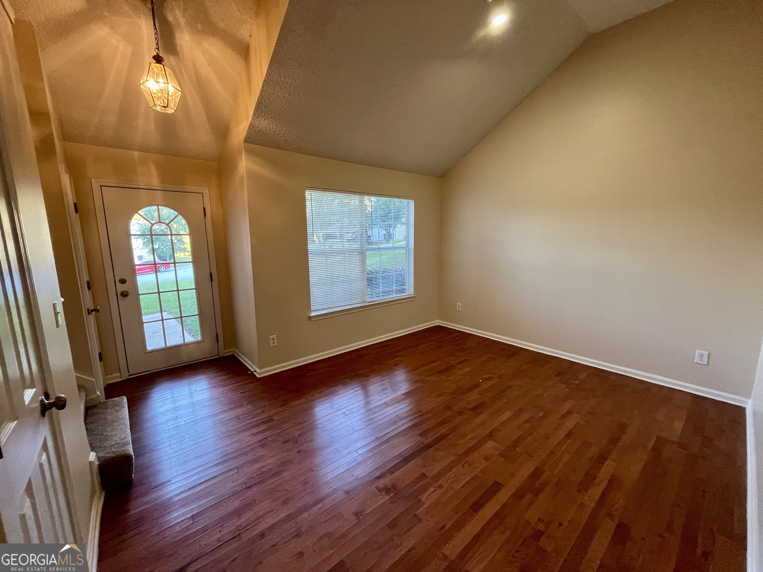 260 Windscape Drive Covington, GA 30016 - Photo 2 of 14 an empty room with wooden floor and windows