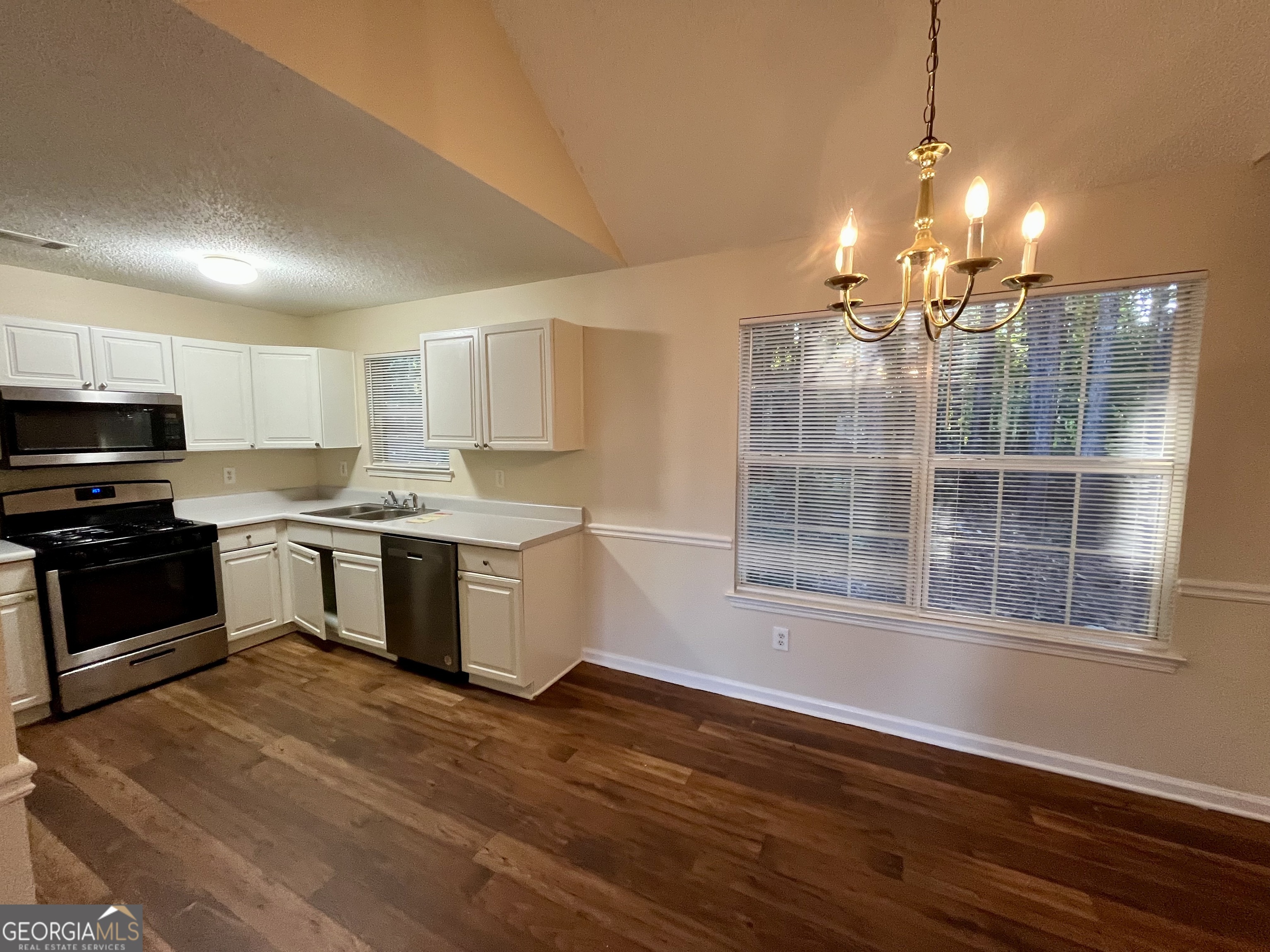 260 Windscape Drive Covington, GA 30016 - Photo 3 of 14 a kitchen with a refrigerator and a stove top oven