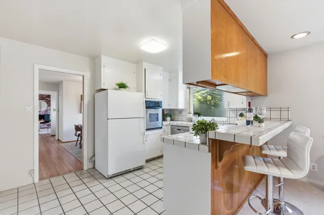 a kitchen view with appliances a sink and a refrigerator
