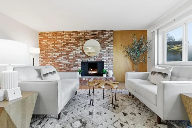 a living room with furniture a large window and a fireplace