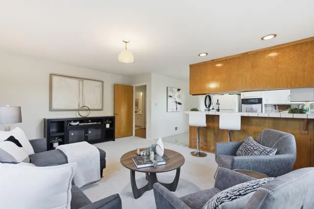 a living room with furniture and kitchen view