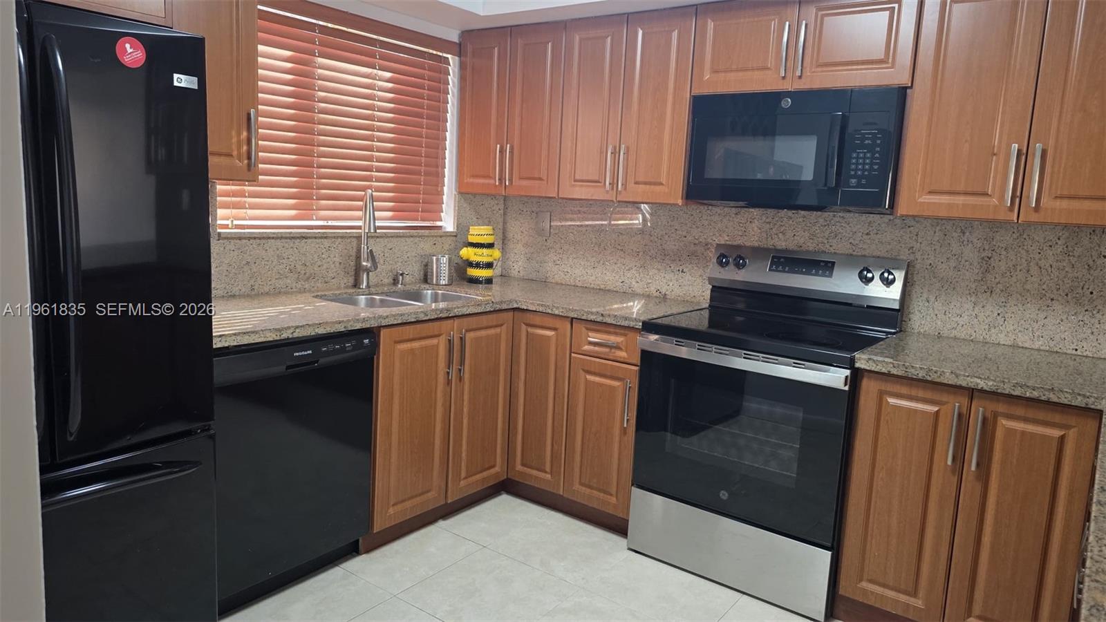 a kitchen with stainless steel appliances granite countertop a sink stove and microwave