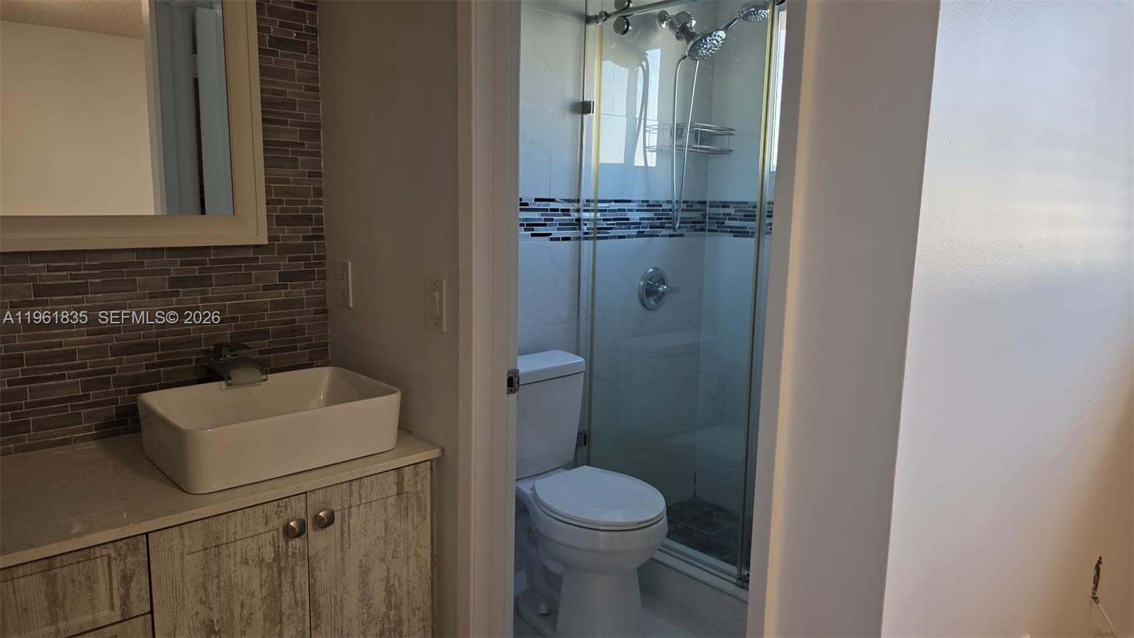 14905 Southwest 80th Street, Unit 217 Miami, FL 33193 - Photo 19 of 25 a bathroom with a toilet a sink and mirror