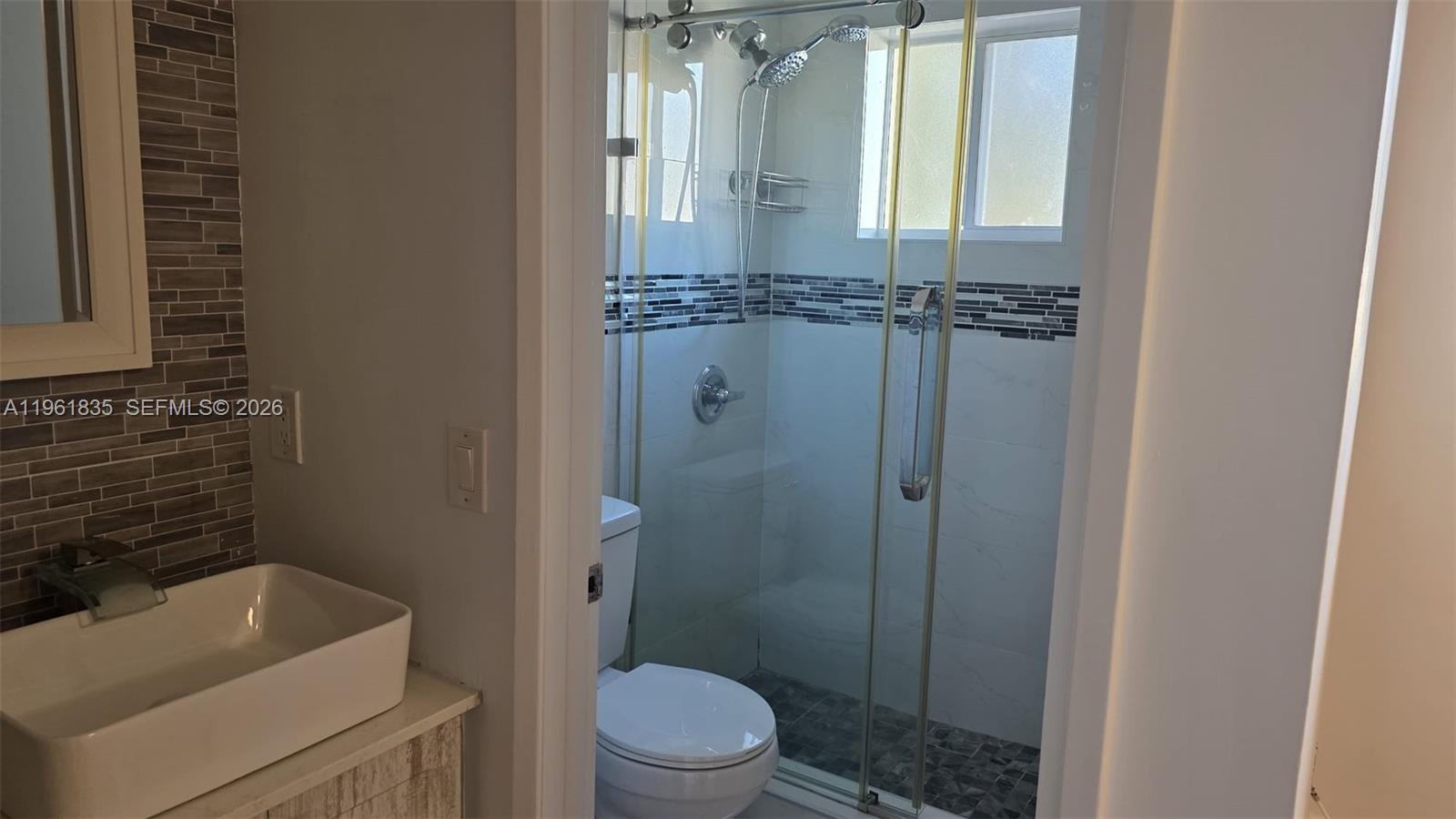 14905 Southwest 80th Street, Unit 217 Miami, FL 33193 - Photo 21 of 25 a bathroom with a toilet a sink and shower