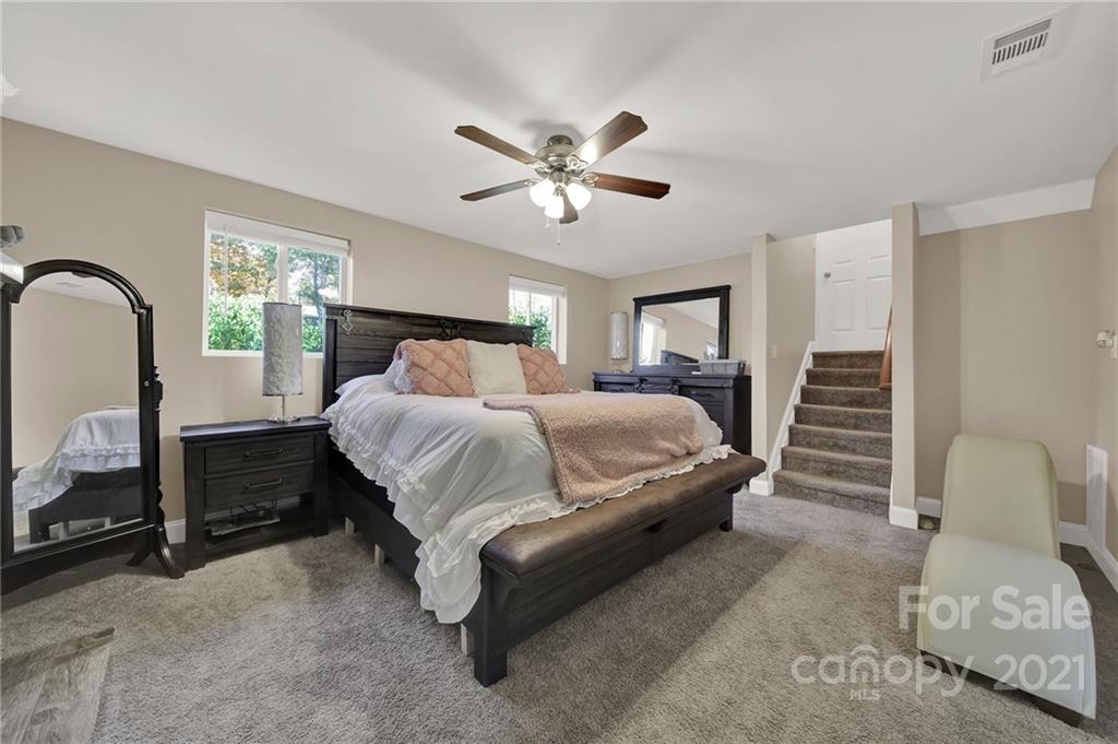 2430 Rice Planters Road Charlotte, NC 28273 - Photo 15 of 42 a bedroom with a bed and a chandelier