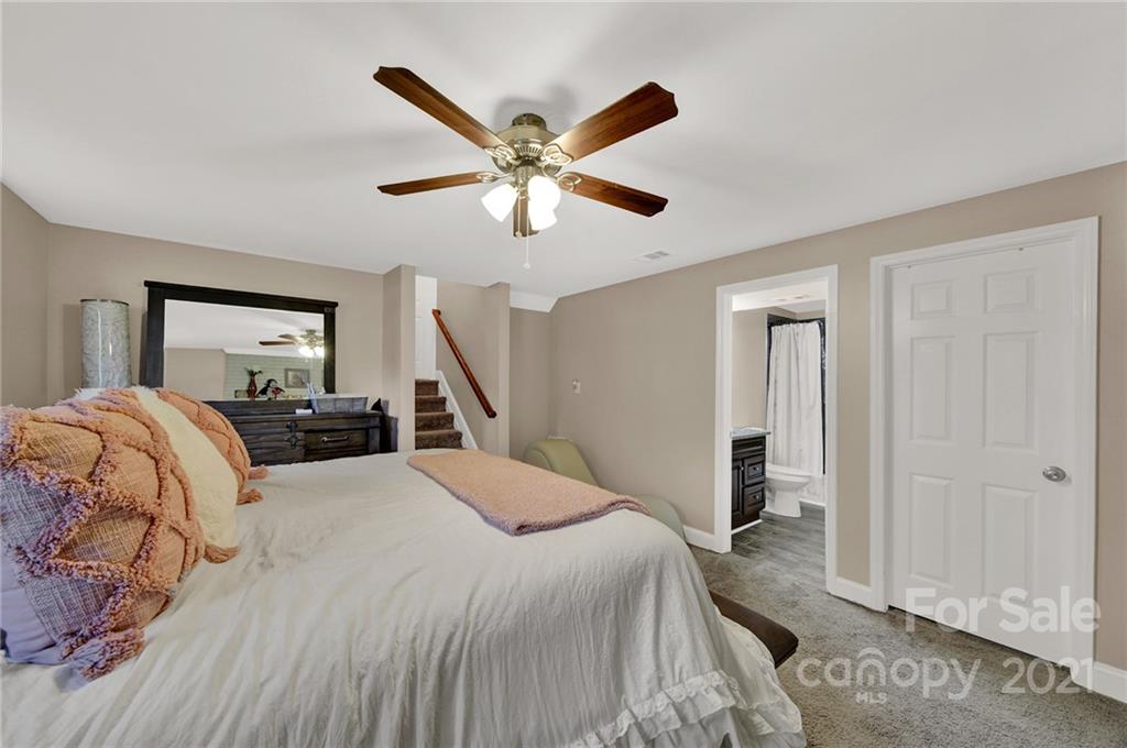 2430 Rice Planters Road Charlotte, NC 28273 - Photo 16 of 42 a bedroom with a large bed and a chandelier