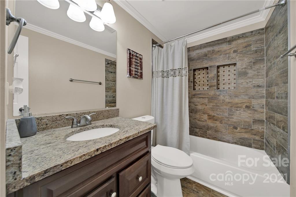 2430 Rice Planters Road Charlotte, NC 28273 - Photo 19 of 42 a bathroom with a granite countertop sink a toilet a mirror and shower