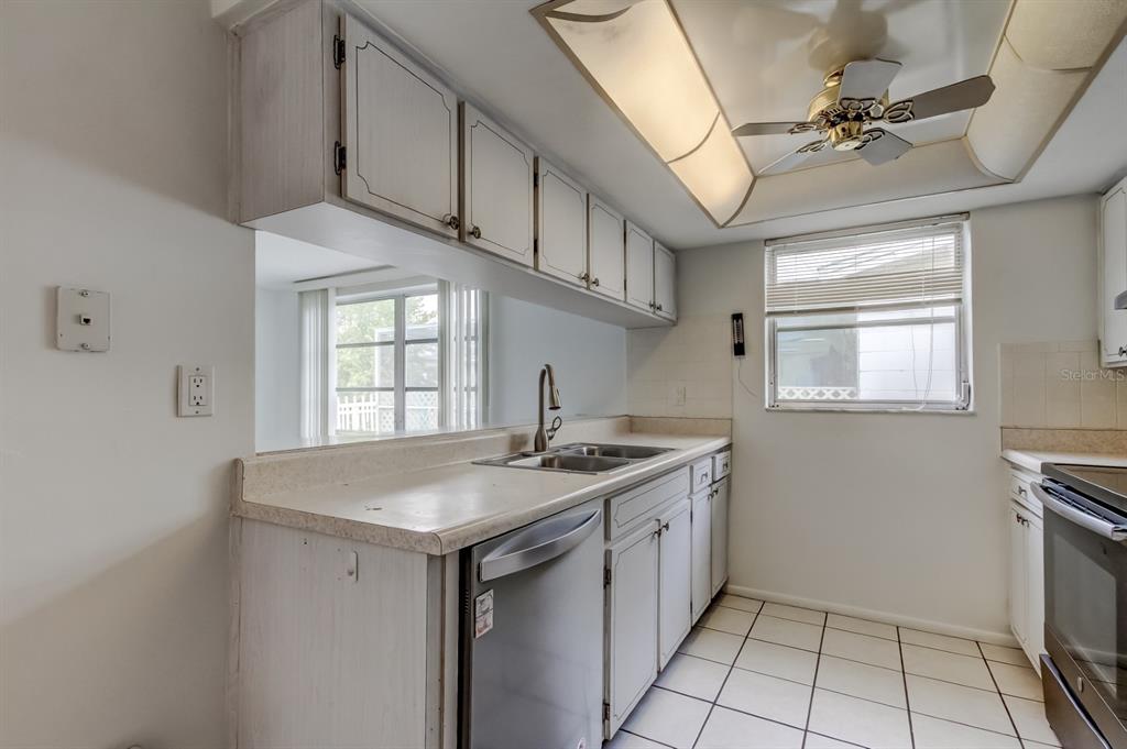 3735 Mynabird Drive New Port Richey, FL 34652 - Photo 19 of 51 a kitchen with stainless steel appliances granite countertop a sink a stove cabinets and a window