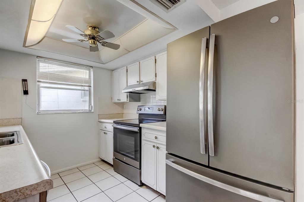 3735 Mynabird Drive New Port Richey, FL 34652 - Photo 20 of 51 a kitchen with stainless steel appliances a refrigerator and a window