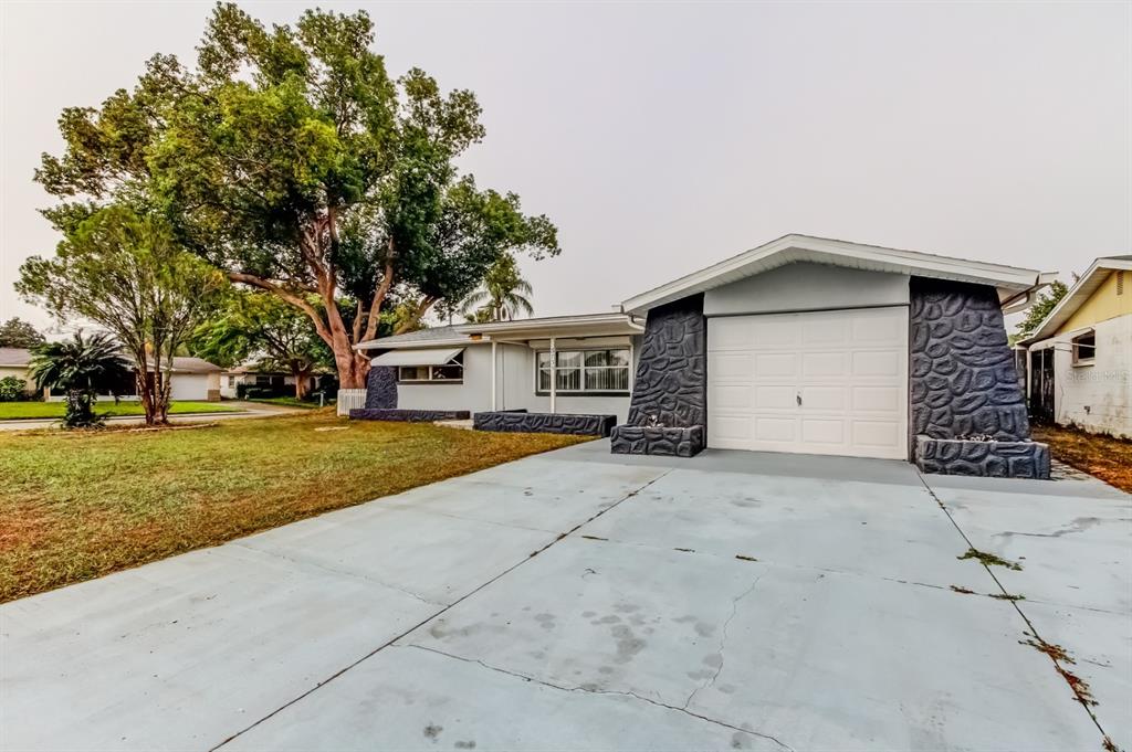 3735 Mynabird Drive New Port Richey, FL 34652 - Photo 2 of 51 a front view of a house with a yard and garage