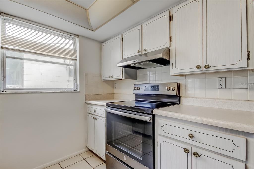 3735 Mynabird Drive New Port Richey, FL 34652 - Photo 21 of 51 a kitchen with granite countertop white cabinets and white appliances