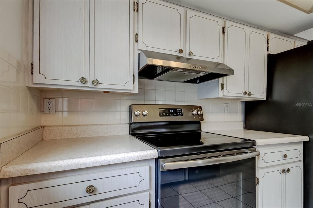 3735 Mynabird Drive New Port Richey, FL 34652 - Photo 22 of 51 a kitchen with stainless steel appliances granite countertop white cabinets and a stove