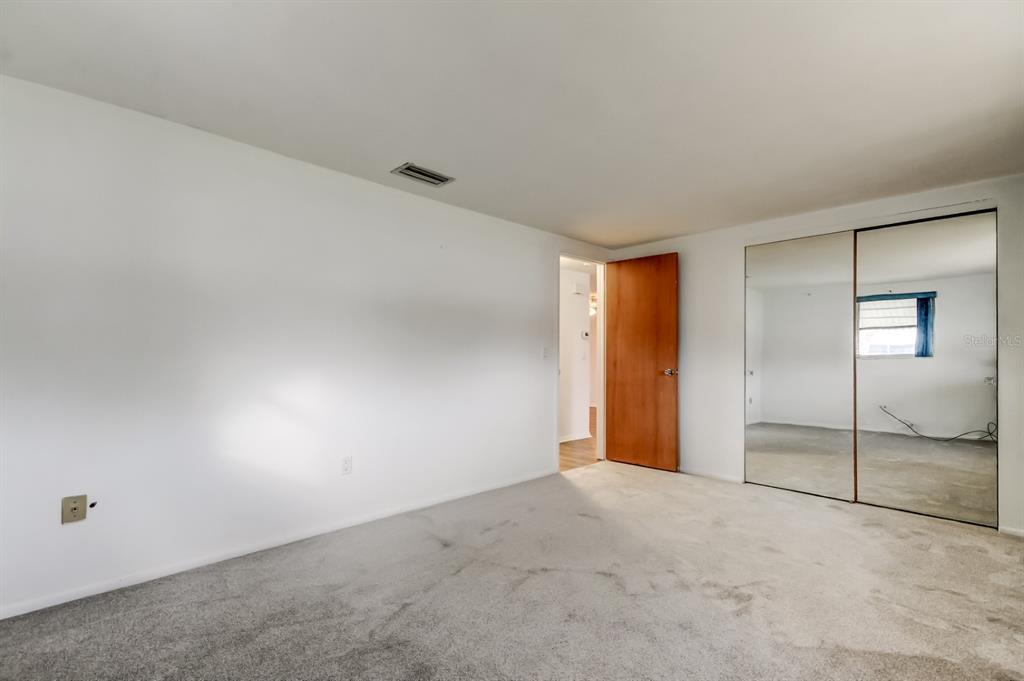 3735 Mynabird Drive New Port Richey, FL 34652 - Photo 35 of 51 an empty room with sliding glass door and chandelier fan