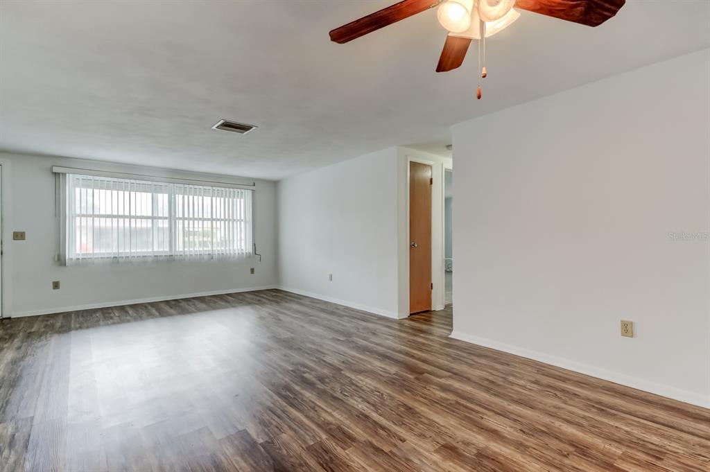 3735 Mynabird Drive New Port Richey, FL 34652 - Photo 8 of 51 wooden floor in an empty room with a window