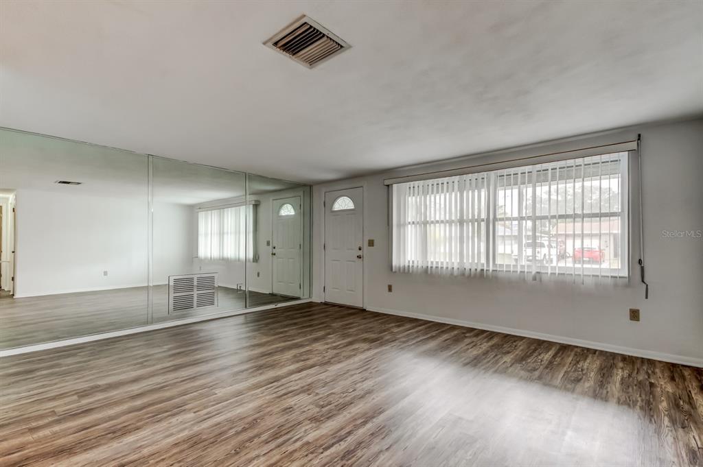3735 Mynabird Drive New Port Richey, FL 34652 - Photo 9 of 51 an empty room with wooden floor and windows