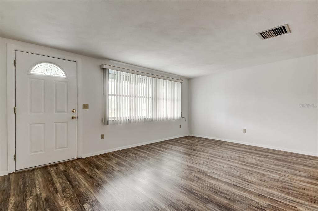 3735 Mynabird Drive New Port Richey, FL 34652 - Photo 10 of 51 an empty room with wooden floor and windows