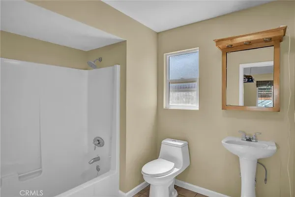 a bathroom with a sink and mirror with toilet