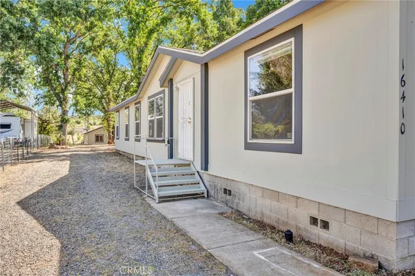 a view of an house with backyard and trees