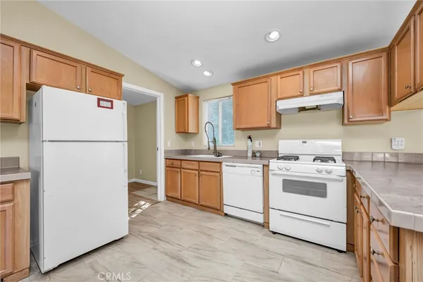 a kitchen with a refrigerator sink stove and cabinets