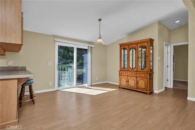 a view of an empty room with window and hardwood floor