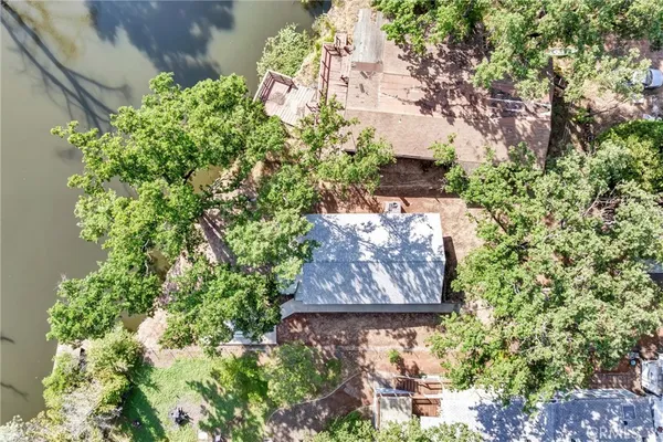 an aerial view of residential houses with outdoor space and trees